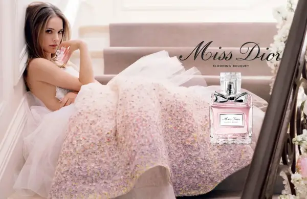 Kobieta w tiulowej sukni trzyma flakonik Miss Dior Blooming Bouquet.