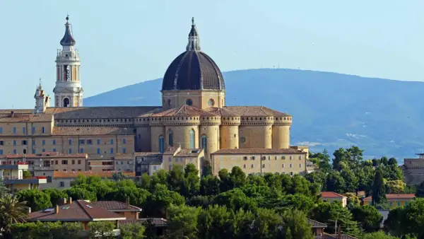 Basilica della Santa Casa a Loreto, vicino Ancona, con la sua imponente cupola e campanile, circondata da verde.
