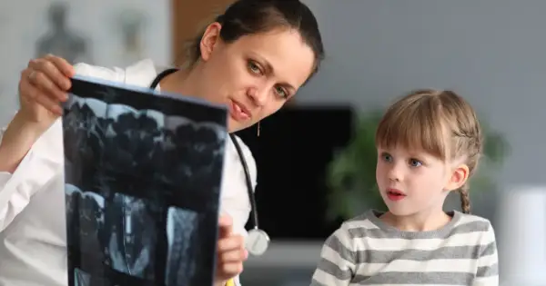 Lekarka, być może neuropsycholog, pokazuje dziecku wyniki rezonansu.