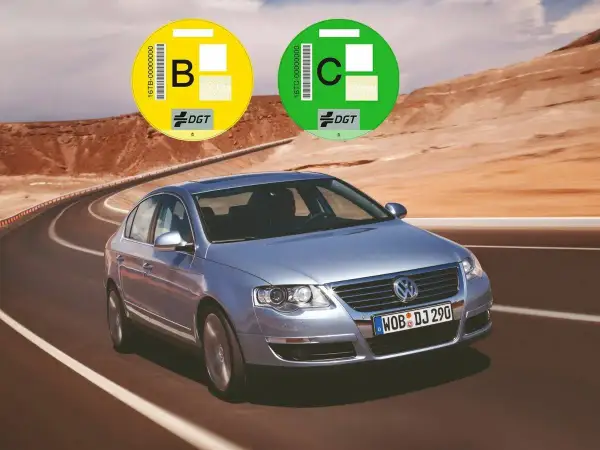 Un coche plateado en una carretera desértica con pegatinas DGT. Averigua como saber si mi coche es Euro 6.