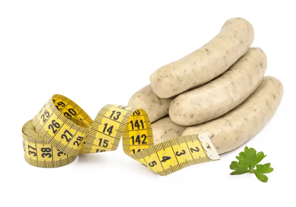 Bratwurst roh essen? Ein Maßband zeigt, dass man auf die Figur achten sollte. Ein Petersilienblatt liegt daneben.