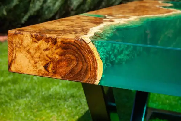 Tavolo con venature di legno e resina epossidica verde brillante, che ricorda un paesaggio marino. Attenzione: la resina epossidica è tossica.
