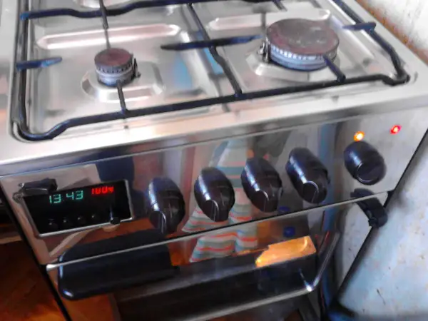 Instrukcja piekarnika Mastercook Wrozamet. Cyfrowy wyświetlacz pokazuje 13:43 i 100°C. Dwie lampki kontrolne świecą się na pomarańczowo i czerwono.