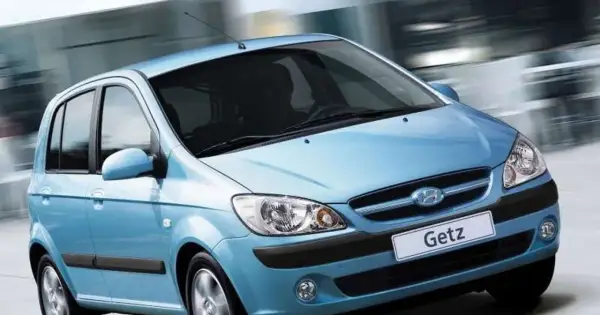 Błękitny Hyundai Getz w ruchu miejskim, z rozmytym tłem sugerującym prędkość.
