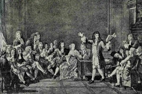 Grupa ludzi w strojach z epoki baroku, jeden mężczyzna przemawia, trzymając książkę.