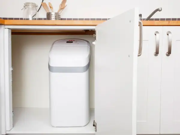 Un adoucisseur nouvelle génération, blanc et compact, est discrètement installé sous l'évier de la cuisine.