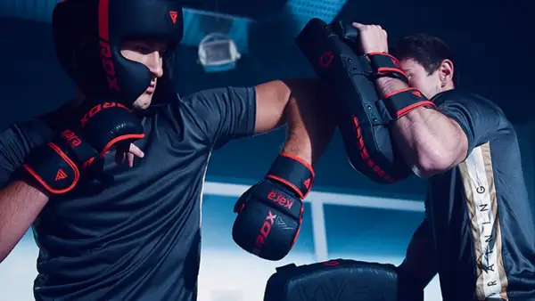 Two boxers train intensely, practicing punches and blocks. This focused training is key to learning how to win a boxing match.