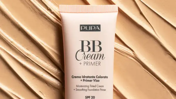 Tubo di BB Cream Pupa su sfondo di texture cremosa. Scopri come mettere la bb cream per un incarnato perfetto.