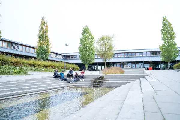 Studierende entspannen sich auf den Treppen vor der Uni Schwerin.