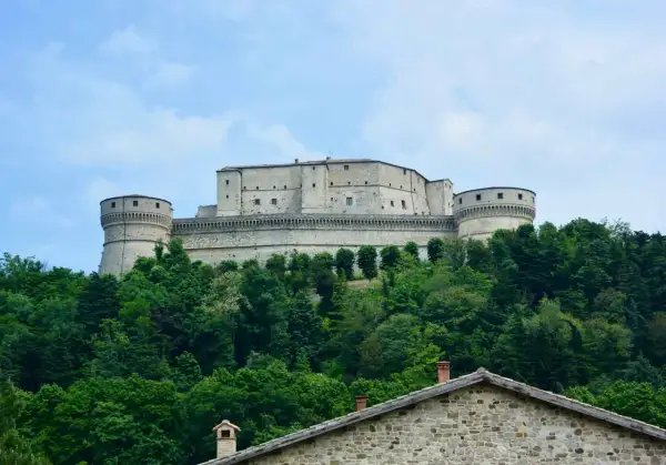 Rocche imponenti e torri rotonde dominano la collina, circondate da un verde lussureggiante. Un gioiello tra i borghi dell'Emilia Romagna.