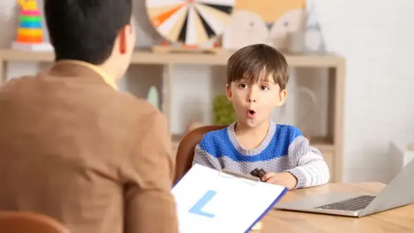 Un niño sorprendido interactúa con un logopeda que es un profesional de la comunicación.