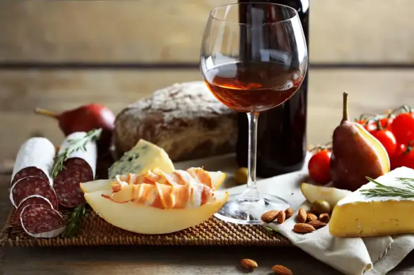 Pyszne wino z Włoch, ser, salami, pieczywo i owoce tworzą idealną przekąskę.