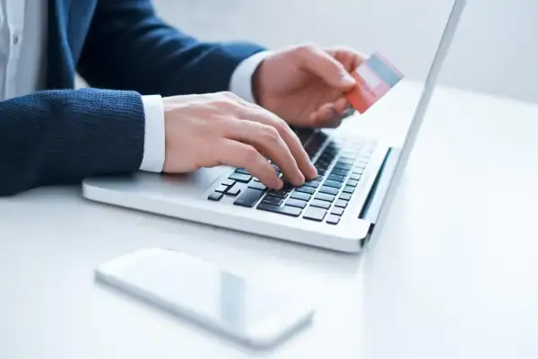 Mężczyzna wpisuje dane karty na laptopie, przygotowując się do aktywacji karty Millenium.