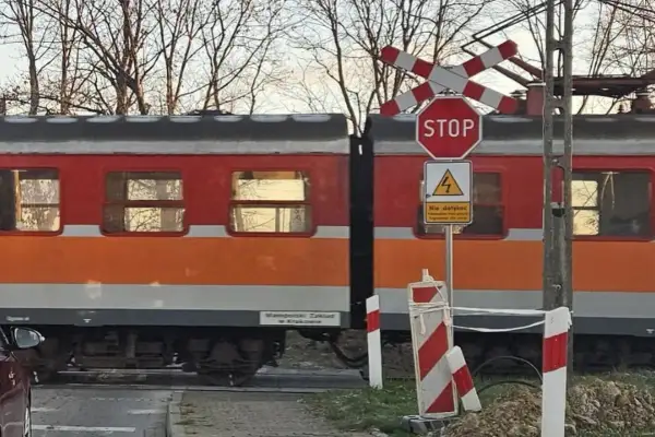 Pociąg na przejeździe kolejowym w Kętach-Bielsku-Białej. Rozkład jazdy pociągów jest kluczowy dla podróżnych.
