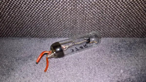 Szklana bańka z elementami elektronicznymi i czerwonymi przewodami. Tak wygląda prostownik, który kiedyś zasilał urządzenia.