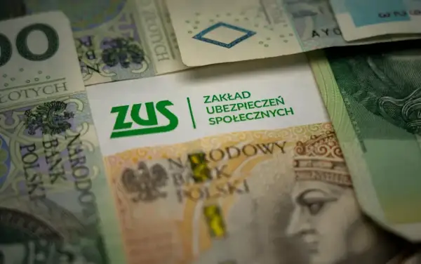 ZUS na tle polskich banknotów. Symbolizuje świadczenie rehabilitacyjne po ustaniu zatrudnienia, zapewniając wsparcie finansowe.