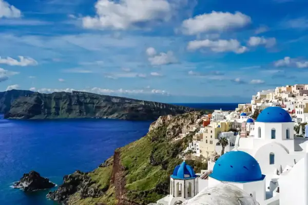 Santorini w maju: błękitne kopuły kościołów, białe domy na klifie i lazurowe morze. Idealna pogoda na zwiedzanie.