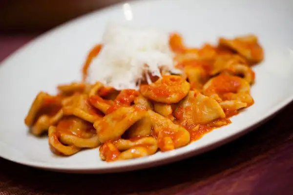 Orecchiette pugliesi con sugo rosso e una spolverata di formaggio grattugiato, un piatto che sa di casa e tradizione.
