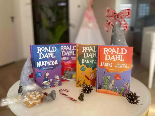 Książki Roald Dahl: Matylda, Charlie i fabryka czekolady, Danny, James i olbrzymia brzoskwinia. W tle świąteczne dekoracje.