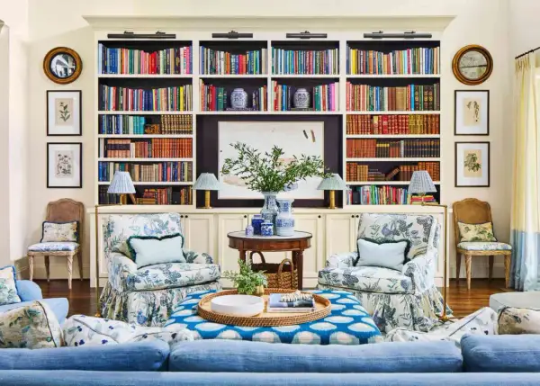 Ideas on how to decorate a bookshelf: a cozy living room with built-in shelves filled with books, art, and decorative vases.
