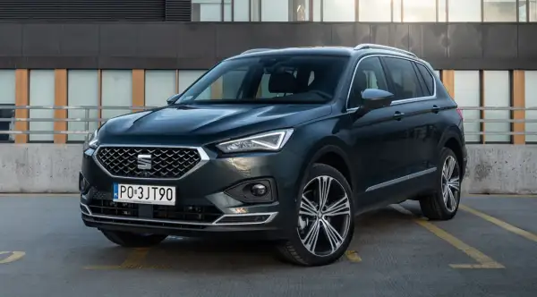 Ciemnozielony SUV z dużym bagażnikiem, zaparkowany na zewnątrz.