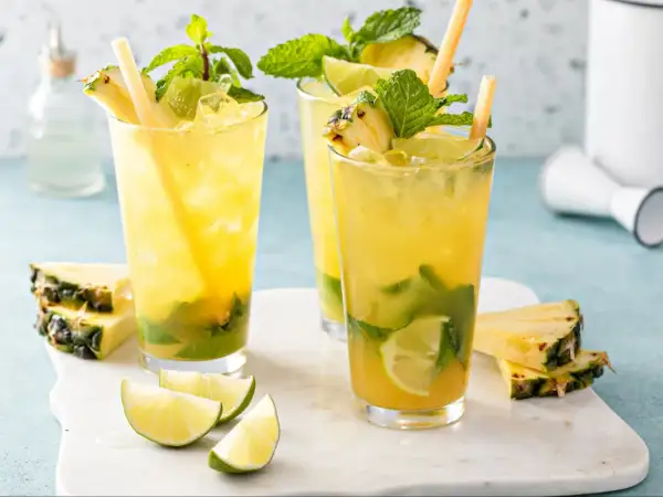 Orzeźwiające augustowskie mojito z ananasem, miętą i limonką, podane z kostkami lodu i słomkami.