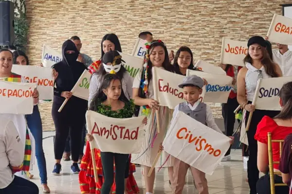 Niños sostienen pancartas con valores como "Amistad", "Civismo" y "Educación", mostrando que es la paz para niños.