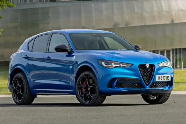 Błękitne Alfa Romeo Stelvio Quadrifoglio z czarnymi felgami i czerwonymi zaciskami hamulcowymi, gotowe do dynamicznej jazdy.