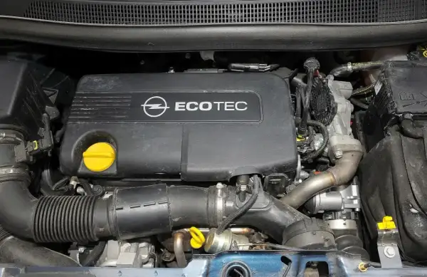 Silnik Ecotec w Opel Meriva 1.7 CDTI. Widoczny czarny plastikowy dekiel z logo Opla i napisem Ecotec, żółty korek oleju, przewody i elementy układu dolotowego.