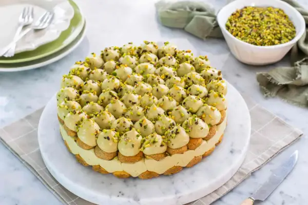 Torta deliziosa con crema al pistacchio e biscotti, decorata con granella di pistacchi. Un vero piacere per gli occhi e il palato.