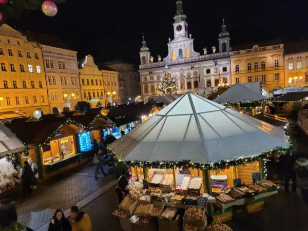 Festlicher budweis weihnachtsmarkt mit beleuchteten Buden, einem Weihnachtsbaum und historischen Gebäuden im Hintergrund.