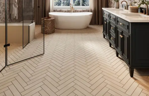 Herringbone floor tiles, likely ceramic or porcelain, create a warm, natural look in this modern bathroom with a freestanding tub and dark vanity.