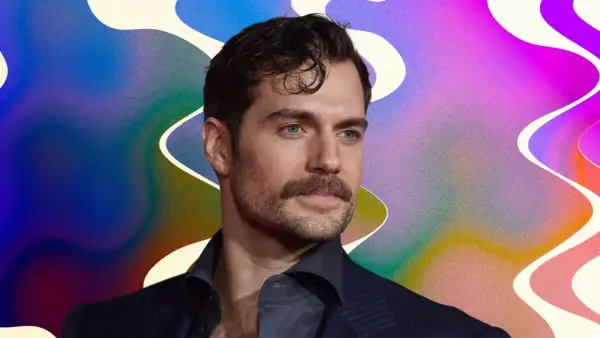 Un homme au regard intense, sa moustache parfaitement taillée, sur un fond abstrait aux couleurs vives.
