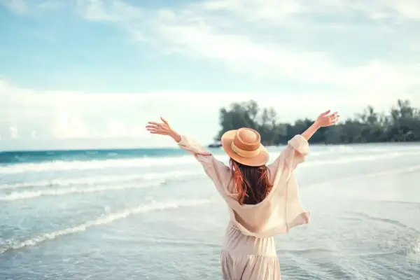 Kobieta w kapeluszu cieszy się plażą, szukając atrakcji dla dzieci pomorskie.