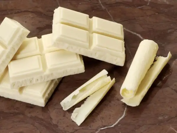 Barras de chocolate blanco, algunas enteras y otras desmenuzadas, demuestran que el chocolate blanco es chocolate.
