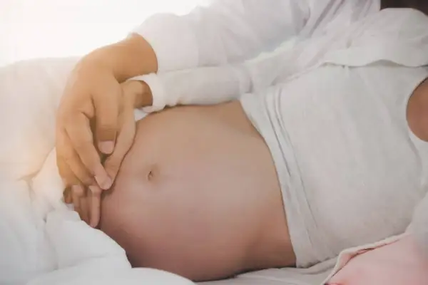 Mani che accarezzano un pancione, un momento speciale quando si inizia a sentire il bambino muoversi.