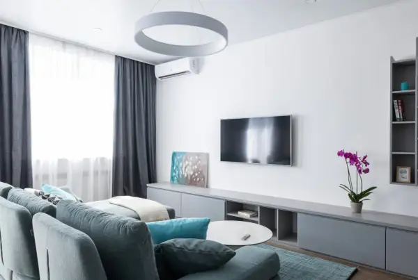 Nowoczesny salon z kanapą, telewizorem i klimatyzacją. Zastanawiasz się, ile kosztuje montaż klimatyzacji?