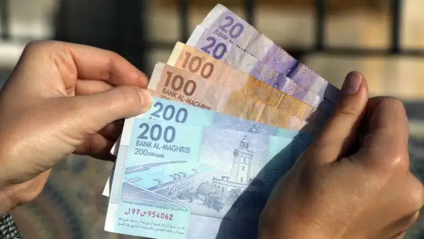 Ręka trzyma marokańskie dirhamy. Czy w Maroko można płacić dolarami? Raczej nie, lepiej mieć lokalną walutę.