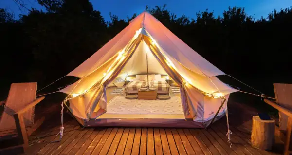 Mysig glampingtält med säng och belysning, redo för en vistelse på nynäshamn camping.