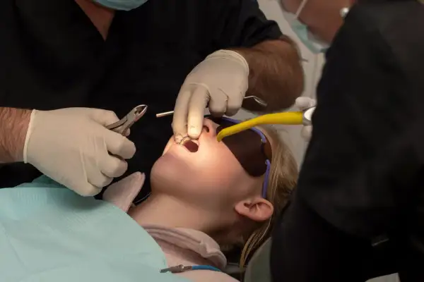 Bambina con apparecchio fisso, forse un po' di dolore nei primi giorni, mentre il dentista lavora sui suoi denti.