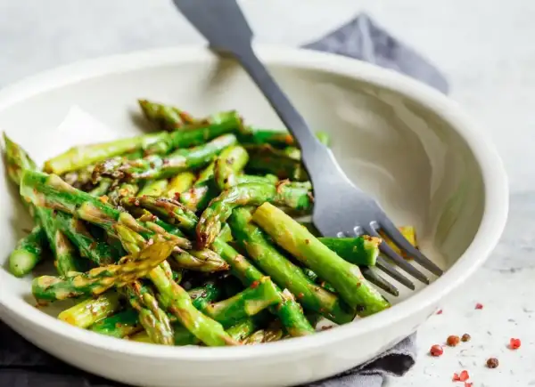 Jak gotować zielone szparagi? Oto pyszne, lekko przypieczone szparagi w misce, gotowe do jedzenia.