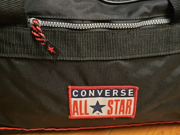 Czarny worek Converse z czerwonymi akcentami i naszywką "All Star". Idealny na treningi i codzienne wyzwania.