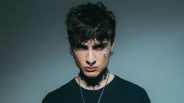 Giovane uomo con piercing e tatuaggi, sguardo intenso, un'aura che ricorda la **rosa chemical**.
