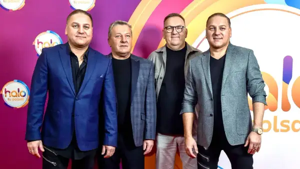 Czterech mężczyzn w eleganckich strojach pozuje na tle logo "halo tu Polsat". Wyglądają jakby właśnie zeszli ze sceny po udanym występie, a ich styl przypomina ściernisko tekst.