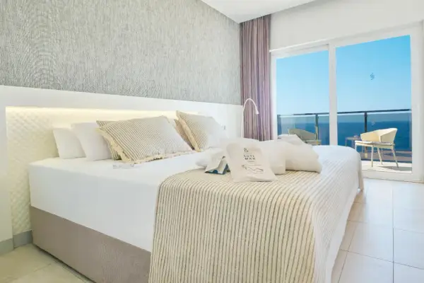 Habitación con cama king, vistas al mar y amenities de Suitopia Spa Calpe.