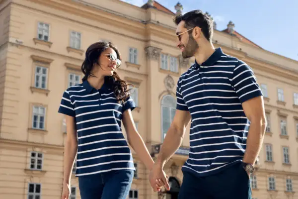 Para spaceru w koszulkach polo. Zobacz, jak nosić koszulka polo damska i męska w pasy, tworząc stylowy duet.