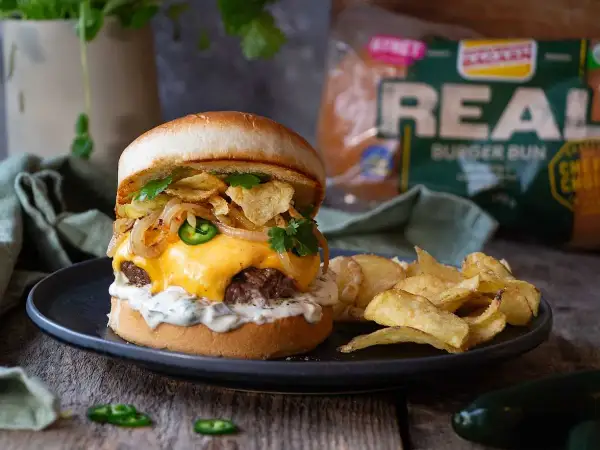 En saftig hamburgare med smält ost, jalapeños, krispiga lökringar och potatischips. Ett perfekt recept för lyxiga hamburgare hemma.