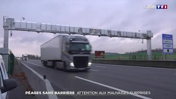 Camion passant sous un portique de péage sans barrière. Le paiement du péage flux libre est automatique.
