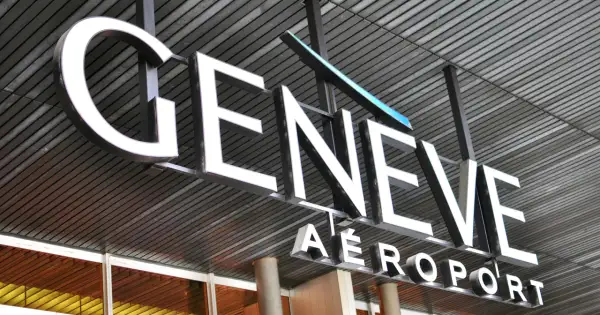 Napis "GENEVE AEROPORT" na tle nowoczesnej architektury, symbolizujący jedne z wielu lotnisk w Szwajcarii.