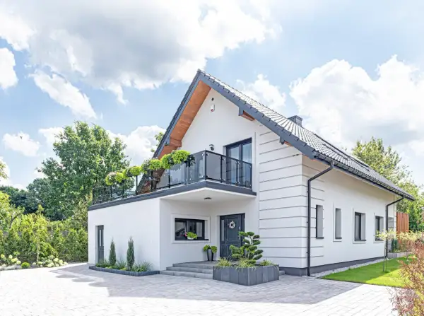 Nowoczesny biały dom z balkonem i zielenią. Idealne miejsce na realizację darmowe projekty domów.